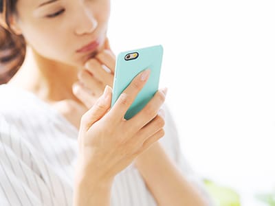 スマホで連絡する女性の写真